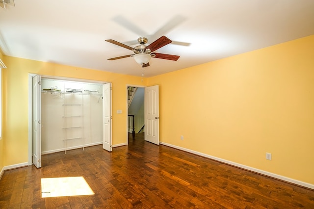 unfurnished bedroom with hardwood / wood-style flooring, baseboards, ceiling fan, and a closet