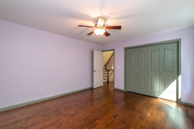 unfurnished bedroom featuring wood finished floors, baseboards, a ceiling fan, and a closet