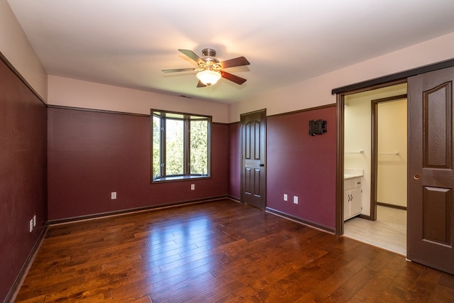 unfurnished bedroom featuring wood finished floors, baseboards, and a ceiling fan