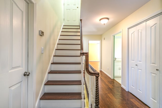 staircase featuring wood-type flooring and baseboards