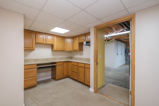 kitchen with a drop ceiling, light countertops, and light carpet