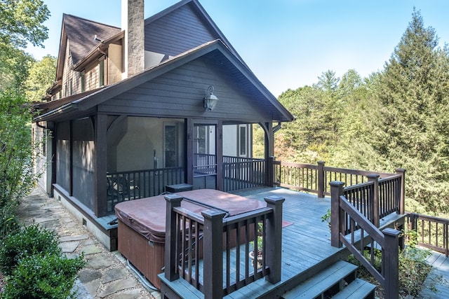 back of house featuring a sunroom, a hot tub, and a deck