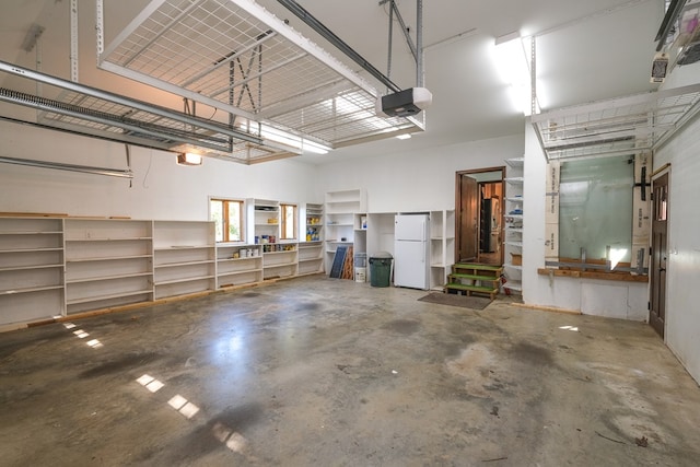 garage with freestanding refrigerator and a garage door opener