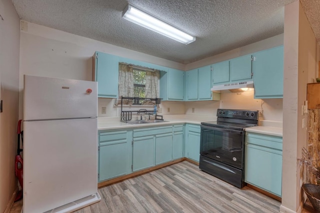 kitchen featuring black range with electric stovetop, under cabinet range hood, freestanding refrigerator, blue cabinets, and a sink