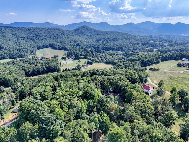 birds eye view of property featuring a mountain view and a wooded view