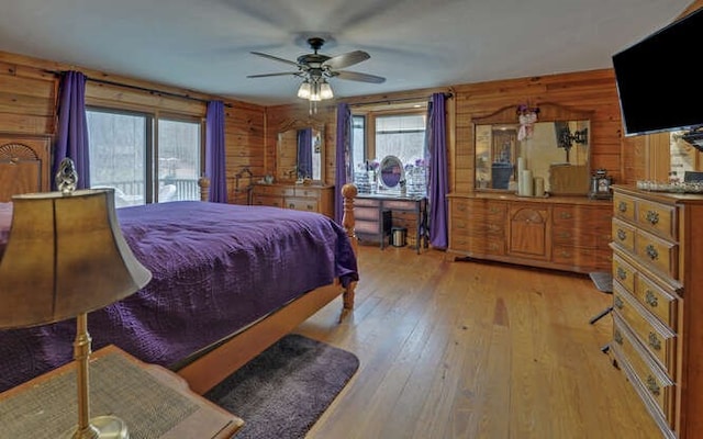 bedroom with access to outside, wood walls, and light wood finished floors