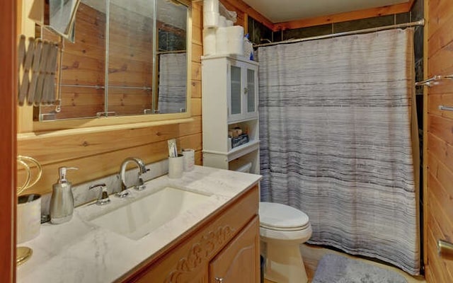 full bath with curtained shower, toilet, wood walls, and vanity