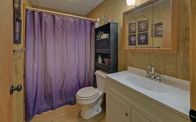 full bath featuring curtained shower, toilet, wood finished floors, and vanity