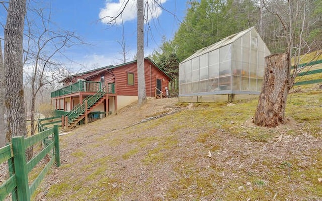 view of yard featuring an exterior structure, an outbuilding, stairs, and fence