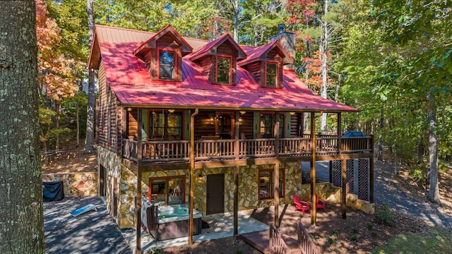 log home with a hot tub and a deck