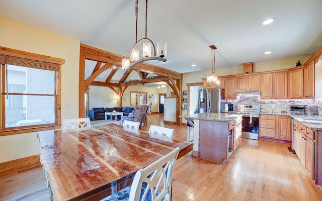 kitchen with pendant lighting, a center island, range with electric stovetop, and light hardwood / wood-style floors