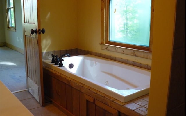 bathroom featuring tile flooring and a bath to relax in