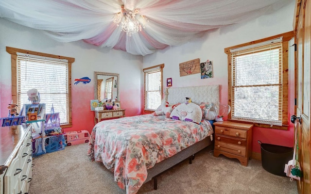 carpeted bedroom featuring a chandelier