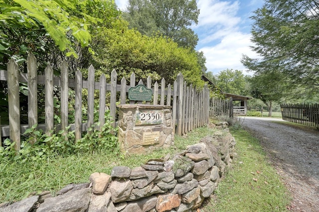 community / neighborhood sign featuring driveway and fence