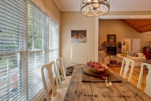 dining space with hardwood / wood-style flooring, wooden ceiling, a premium fireplace, lofted ceiling with beams, and a chandelier