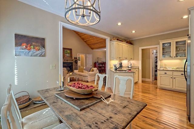 10 Quiet Place Ln, Clayton, GA 30525 - dining space with crown molding, light wood-type flooring, a chandelier, recessed lighting, and a stone fireplace