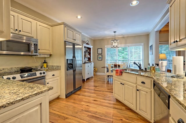 kitchen featuring sink, light hardwood / wood-style floors, stainless steel appliances, pendant lighting, and crown molding