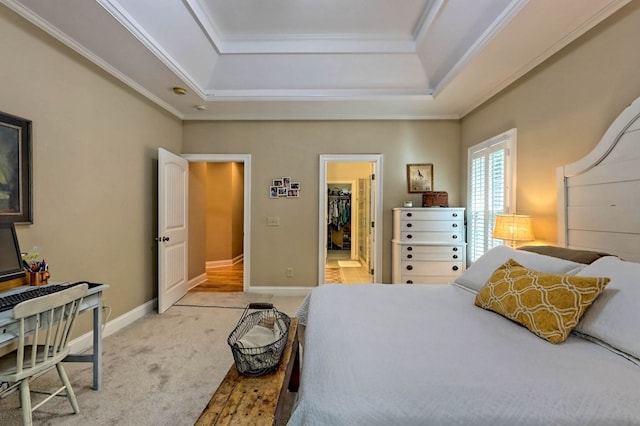 carpeted bedroom with a spacious closet, crown molding, and a raised ceiling