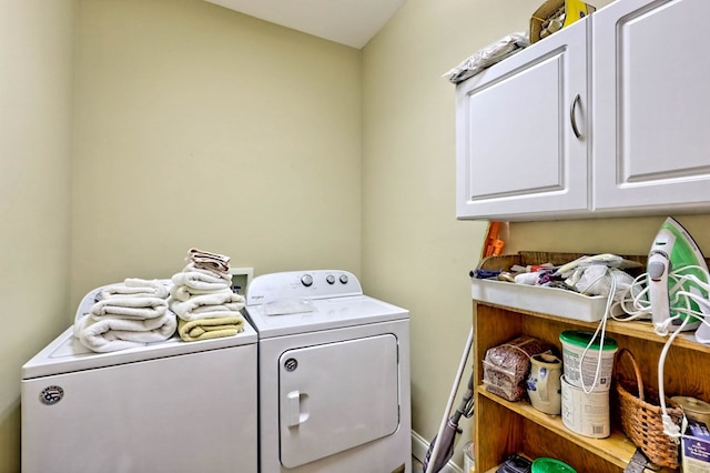 laundry room featuring washer and dryer and cabinets