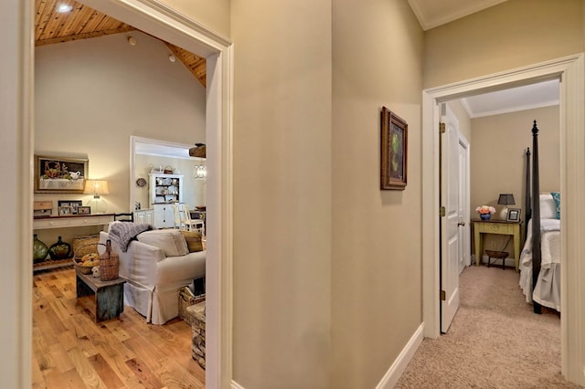 hall with light hardwood / wood-style floors, high vaulted ceiling, wooden ceiling, and ornamental molding