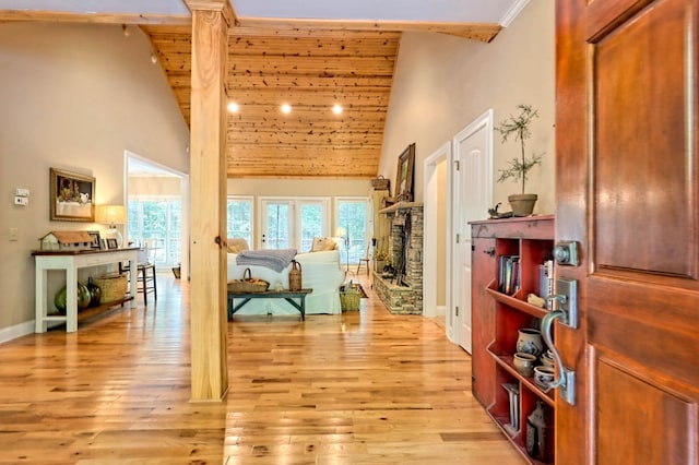 hall featuring light hardwood / wood-style flooring and high vaulted ceiling