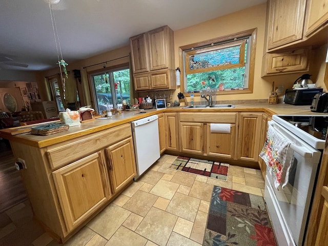 kitchen featuring kitchen peninsula, sink, and white appliances