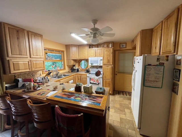 kitchen with sink, kitchen peninsula, ceiling fan, backsplash, and white appliances