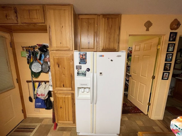 kitchen featuring light brown cabinets, hardwood / wood-style floors, and white refrigerator with ice dispenser