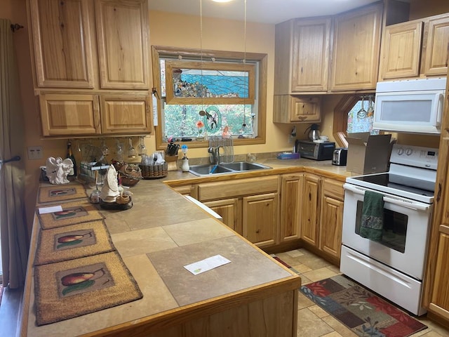 kitchen featuring white appliances, tile countertops, and sink