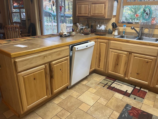 kitchen with tile counters, sink, a healthy amount of sunlight, and white dishwasher