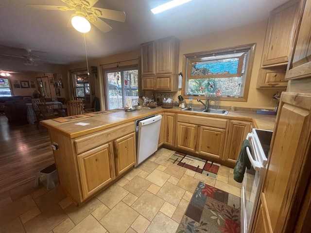 kitchen with white dishwasher, kitchen peninsula, stove, sink, and ceiling fan