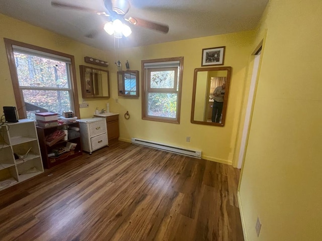 office featuring baseboard heating, dark hardwood / wood-style flooring, a textured ceiling, and ceiling fan