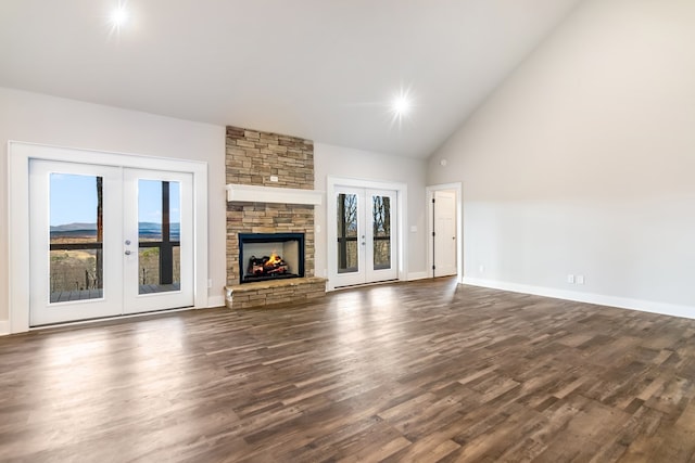 unfurnished living room with french doors, a fireplace, dark hardwood / wood-style flooring, and high vaulted ceiling