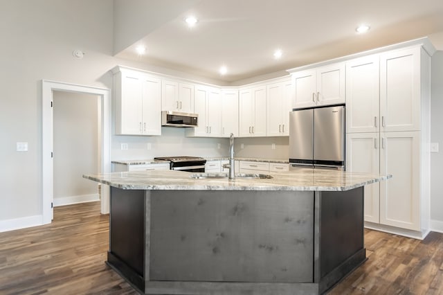 kitchen with dark wood finished floors, appliances with stainless steel finishes, white cabinetry, a sink, and light stone countertops