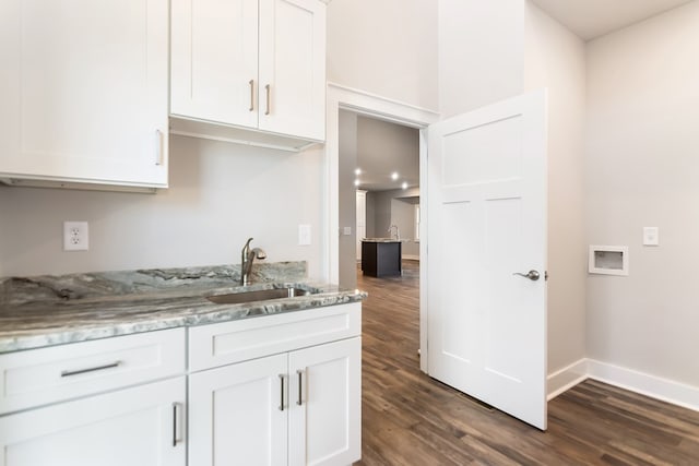 kitchen featuring white cabinetry, sink, dark wood-type flooring, and light stone countertops