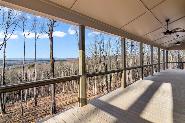 wooden deck featuring ceiling fan and a wooded view