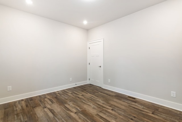 spare room featuring dark wood-type flooring, recessed lighting, visible vents, and baseboards