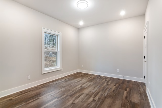 spare room with dark wood finished floors and baseboards