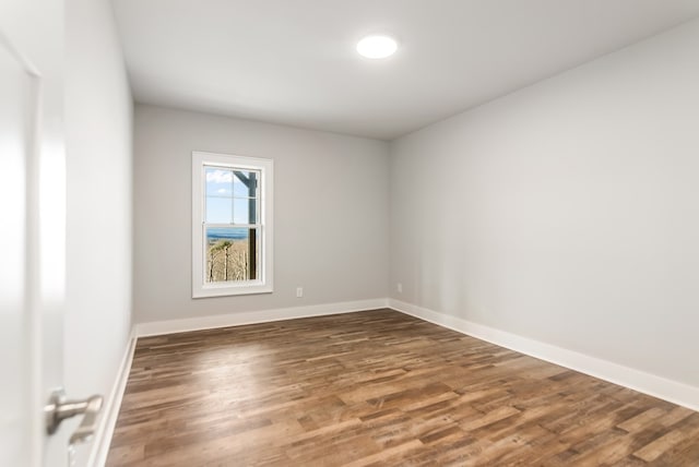 empty room with dark hardwood / wood-style flooring