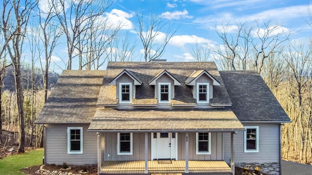 view of front of house with a porch, board and batten siding, and roof with shingles