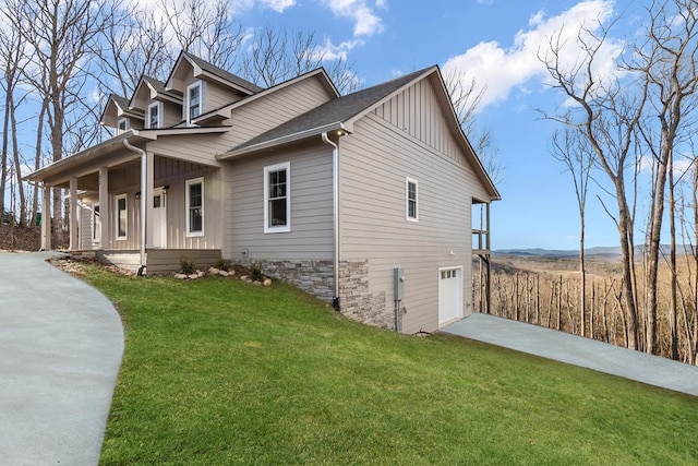 view of front of house with a garage, covered porch, and a front lawn