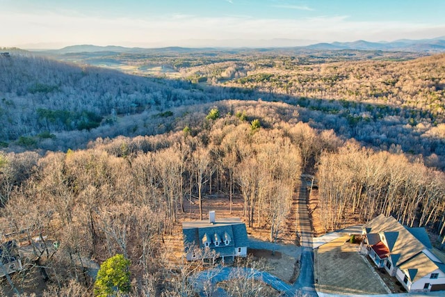 birds eye view of property featuring a mountain view and a wooded view