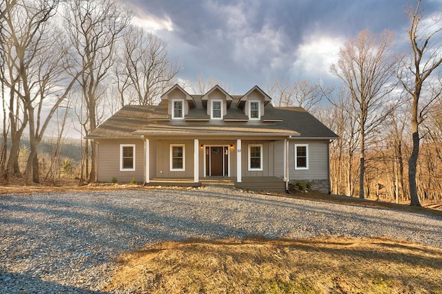 cape cod home with a porch and driveway