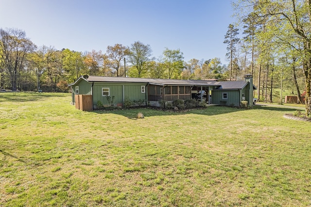 rear view of house with a sunroom and a yard