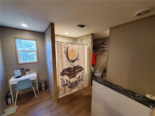 bathroom featuring hardwood / wood-style floors, a shower with curtain, and a textured ceiling