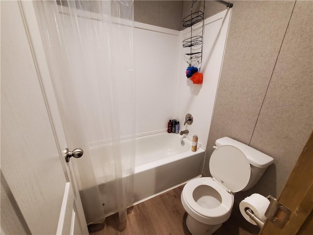 bathroom featuring hardwood / wood-style flooring, toilet, and shower / bathtub combination