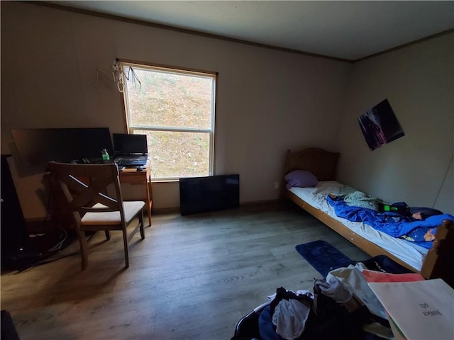 bedroom featuring ornamental molding and light hardwood / wood-style flooring