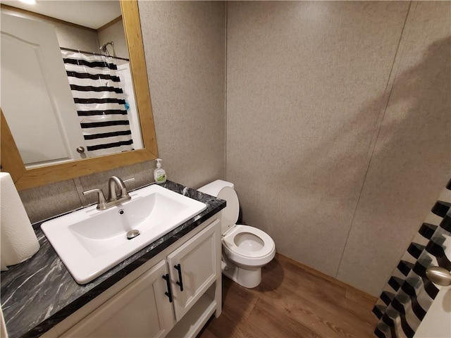 bathroom with hardwood / wood-style flooring, vanity, and toilet