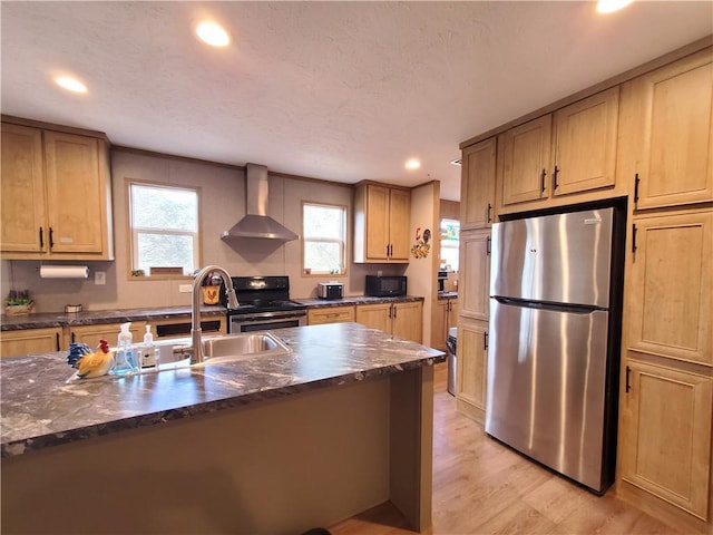 kitchen featuring black appliances, wall chimney range hood, sink, light hardwood / wood-style flooring, and a textured ceiling