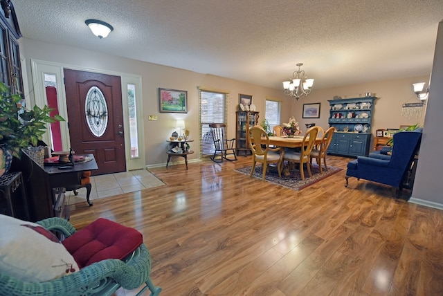 entrance foyer with a chandelier, a textured ceiling, and light hardwood / wood-style floors